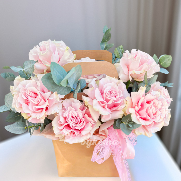 Коробочка с розовыми розами и эвкалиптом (крупный план)